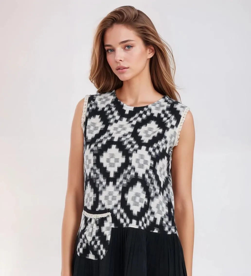 Woman wearing a black and white patterned sleeveless dress on a white background