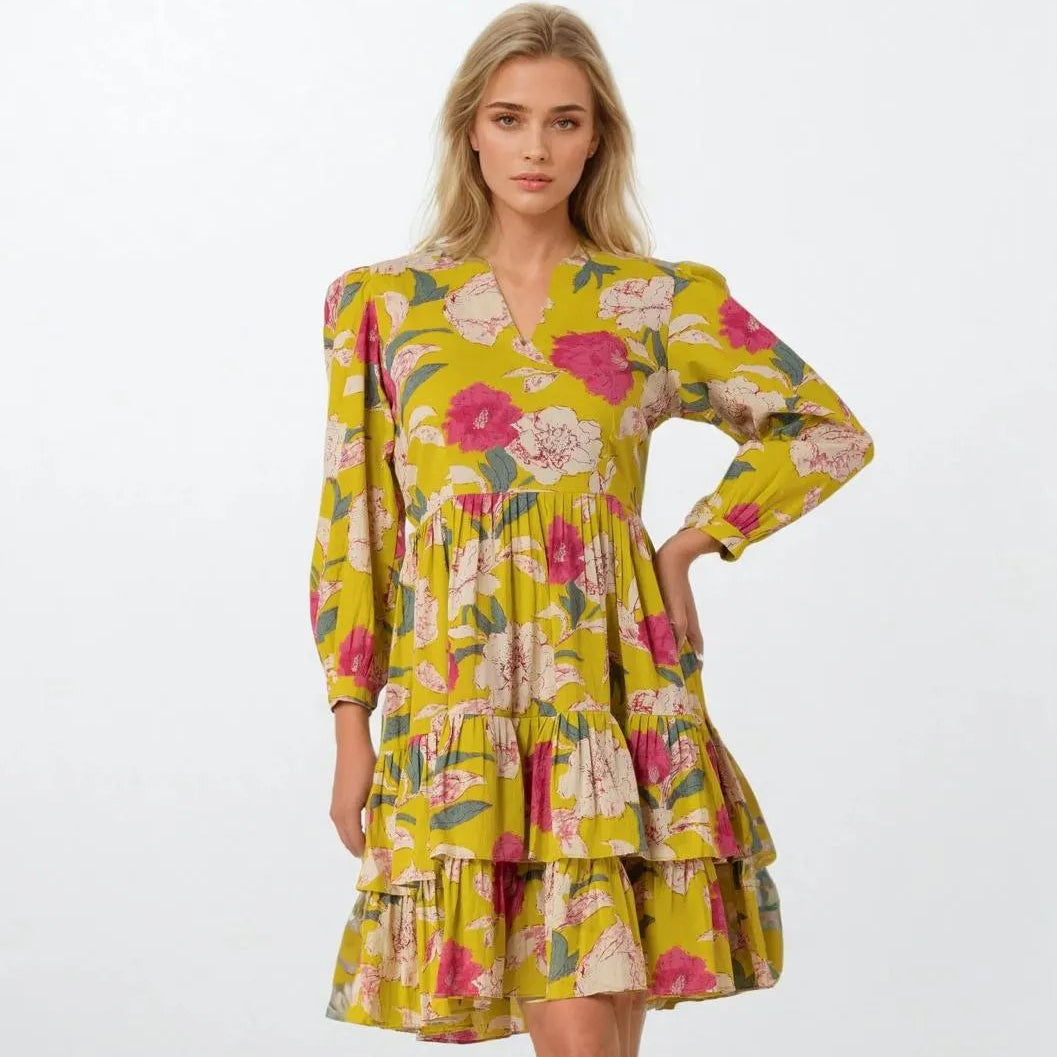 Woman wearing a yellow floral dress on a white background